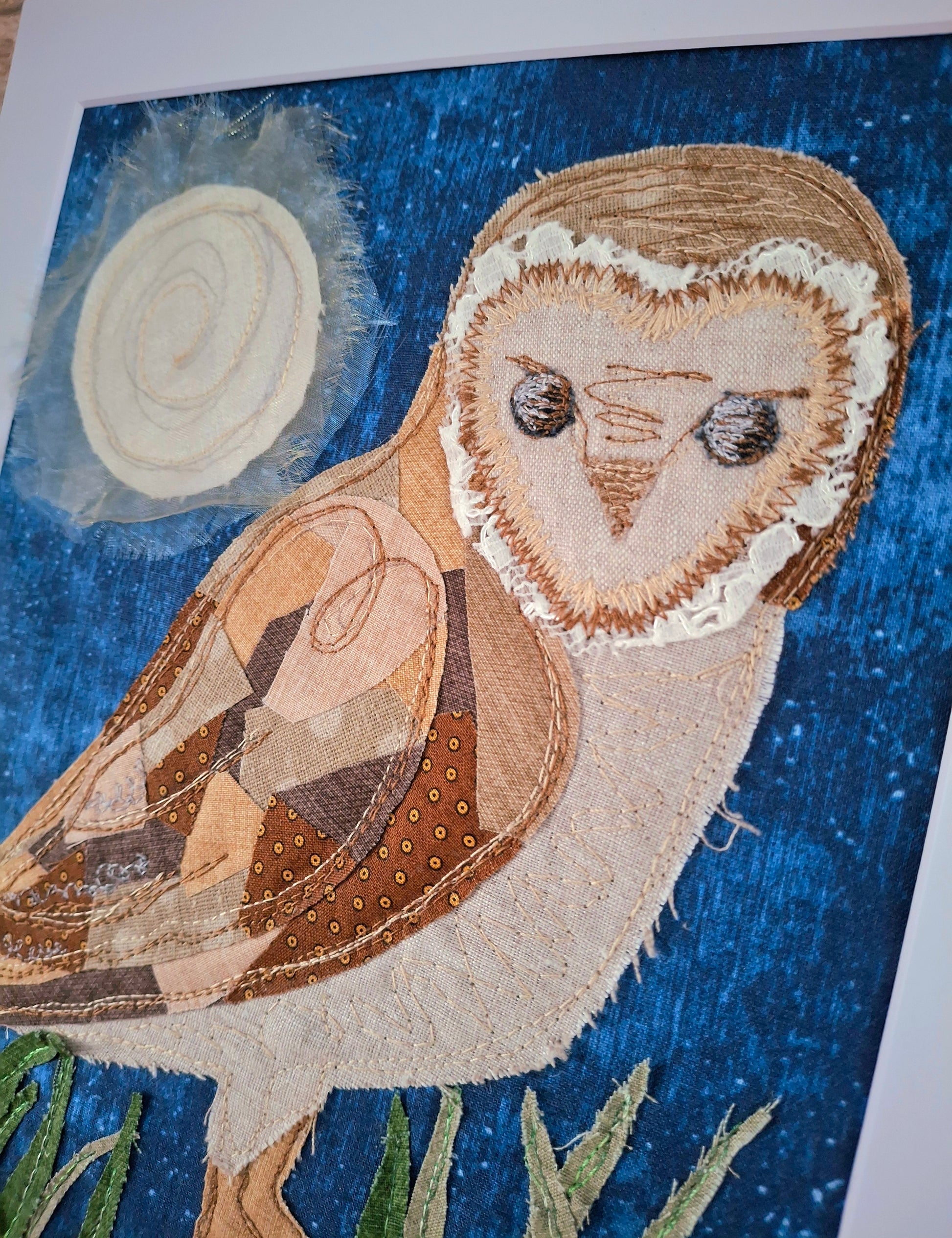 Textile art of an owl on a blue background